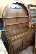 A 1.22m Old Charm stained oak two part dresser with dome-top two shelf open plate rack, two frieze