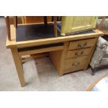 A 1.3m modern light oak single pedestal desk with inset writing surface and three graduated pedestal