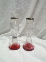A pair of early 20th Century cranberry and clear glass specimen vases with applied silver rims and