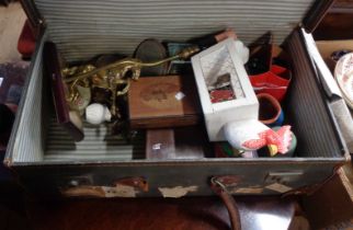 A suitcase containing assorted collectable items including a chicken egg holder, brass horse lamp,