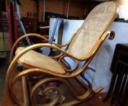 A modern bentwood framed elbow rocking chair with rattan back and seat panel