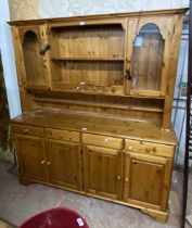 A 1.71m Ducal modern pine dresser with two shelf plate rack and flanking glazed cupboard doors, four