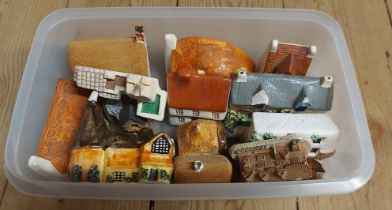 A tub containing a quantity of miniature ceramic house models of various form and maker