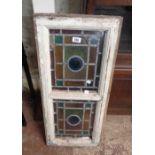 An antique white painted wood framed leaded window with two stained glass panels