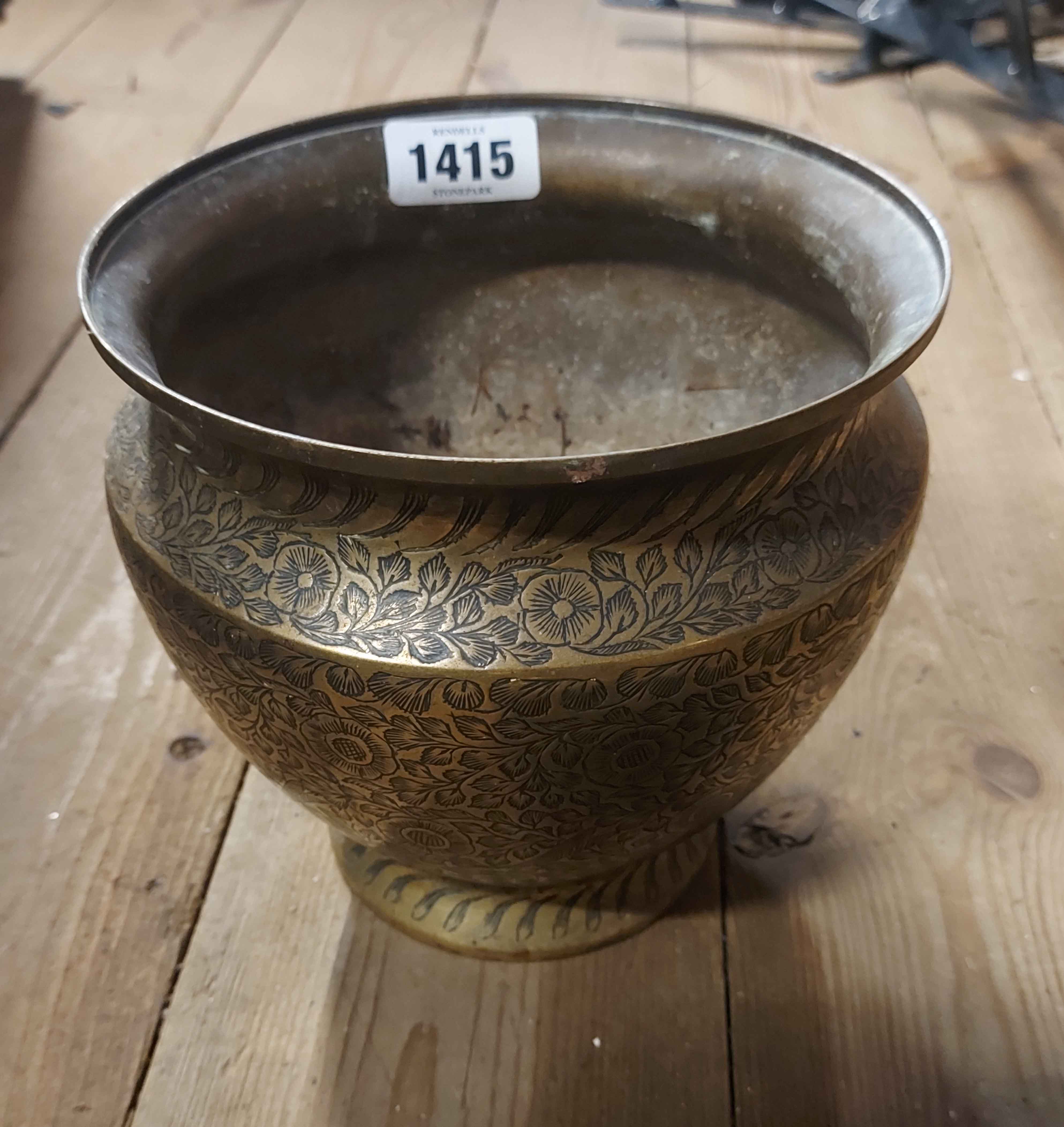 A brass pot with all around etched floral decoration