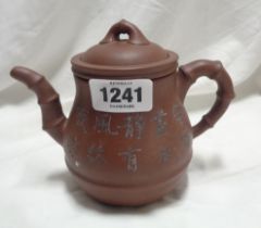 A Chinese Yixing Zisha clay teapot with incised calligraphic and bamboo decoration with internal