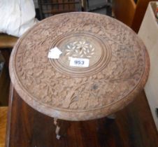 A small Eastern carved table with folding base
