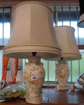 A pair of ceramic lamps with floral decoration on a cream ground