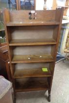 A 59cm Arts & Crafts oak four shelf open bookcase with pierced decoration to top, set on shaped