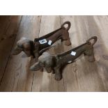 A pair of cast iron boot scrapers of dachshund form