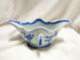 An antique Chinese porcelain sauce boat, of double ended form with blue painted panelled decoration