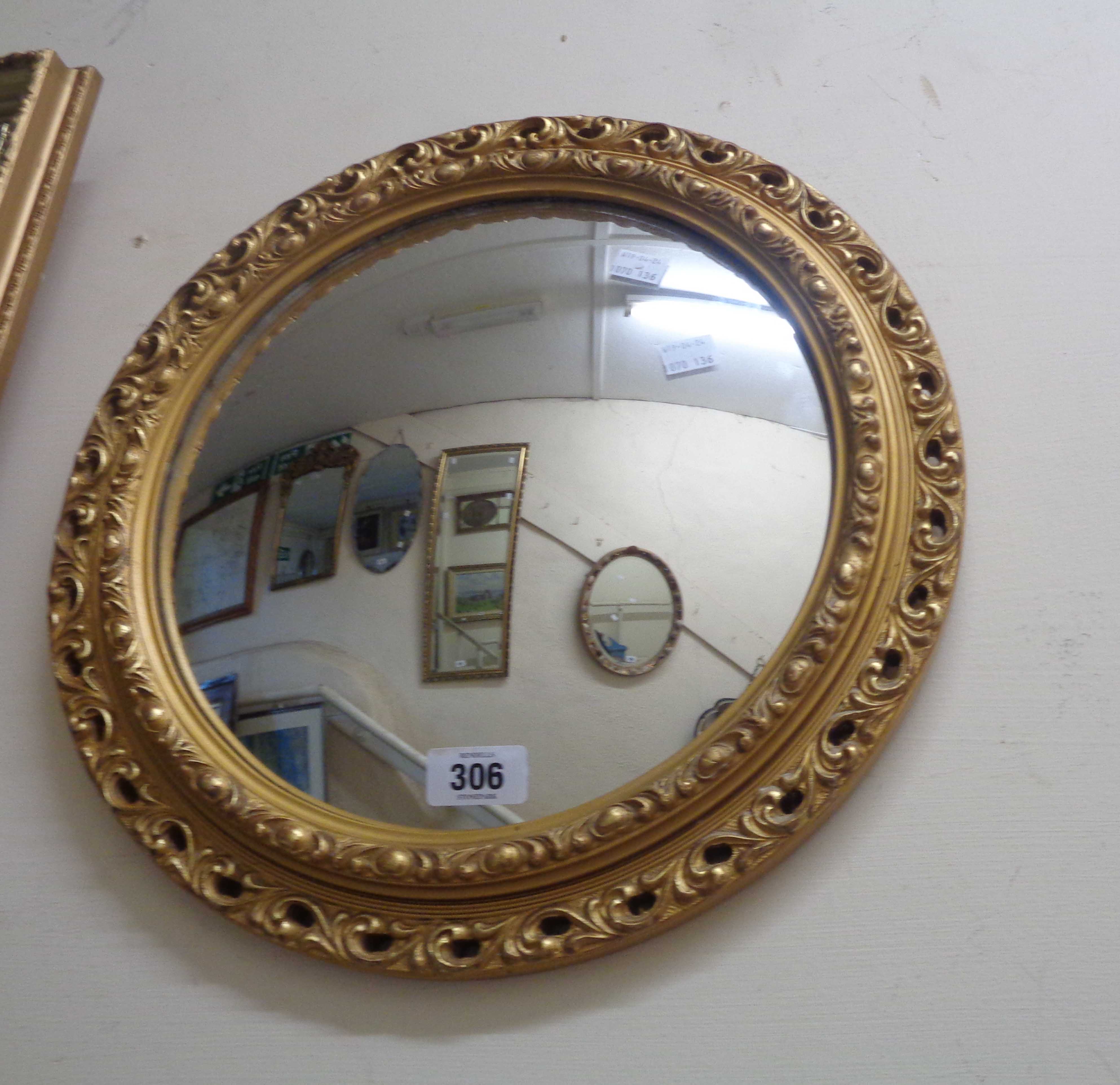 A small gilt framed convex wall mirror with decorative border