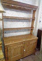 A 1.17m Victorian pine two part dresser with two shelf open plate rack and cup hooks, over a base