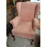 A vintage Parker Knoll wingback armchair with pink tapestry upholstery, set on cabriole front legs