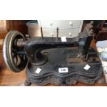 An antique cast iron sewing machine, set on decorative lion scroll base