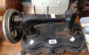 An antique cast iron sewing machine, set on decorative lion scroll base