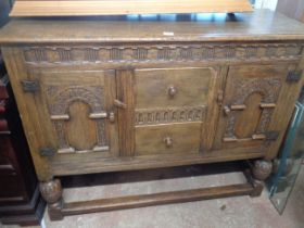 A 1.37m reproduction oak sideboard with two central deep drawers and flanking carved panelled