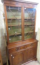 A 98cm reproduction mahogany two part book cabinet with painted adjustable shelves enclosed by a