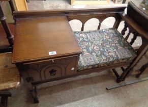 A 95cm retro Chippy oak telephone table with memory slide and cupboard under, set on turned