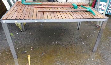 A modern metal garden table with slated wooden top