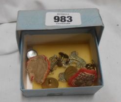 A small box containing military pins and buttons including Kings African Rifles cap badge, etc.