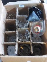 A box containing a quantity of drinking glasses including branded advertising examples