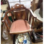 An Edwardian mahogany and strung framed bow elbow chair with upholstered seat panel, set on turned