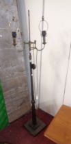 An industrial style metal twin branch standard lamp, set on stepped square base