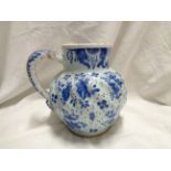 An antique Delft jug with wrythen form body, short neck and rope twist handle, decorated in blue