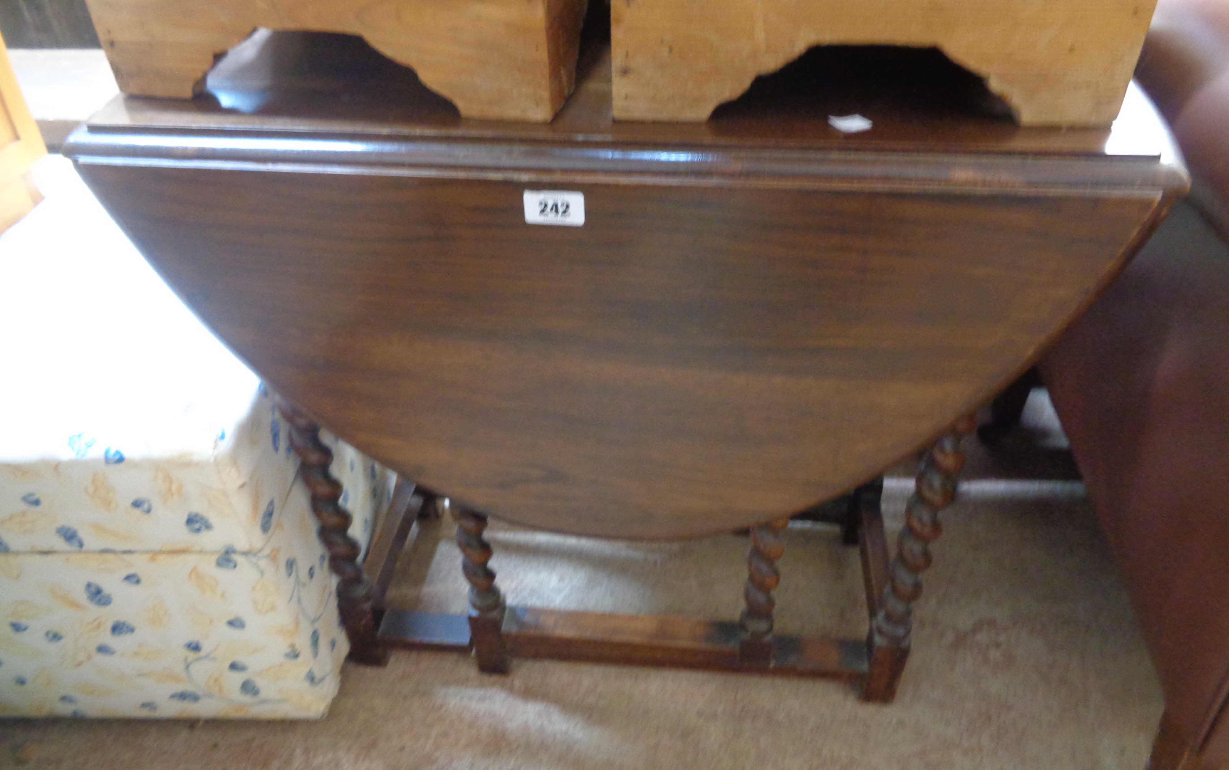 A 72cm early 20th Century stained oak gateleg table, set on barley twist supports