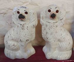 A pair of 19th Century Staffordshire comforter spaniels, with gilt decoration and inset glass eyes