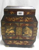A late Meiji period Japanese lacquered table cabinet with lift-top compartment, two long drawers and