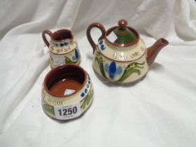 A Longpark Torquay tea set comprising teapot, jug and sugar bowl, with Scandy decoration and motto