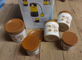 A box containing five Denby stoneware storage jars with floral decoration on an oatmeal glaze