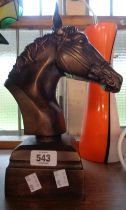 A modern horse head ornament set on plinth base