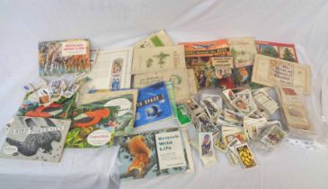 A box containing a collection of loose vintage cigarette cards including large format Wills'