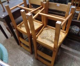 A set of four modern light oak ladder back dining chairs with woven seat panels