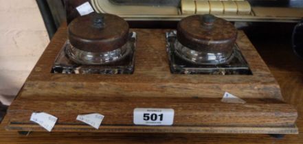 A pair of twin glass inkwells set within a wooden stand