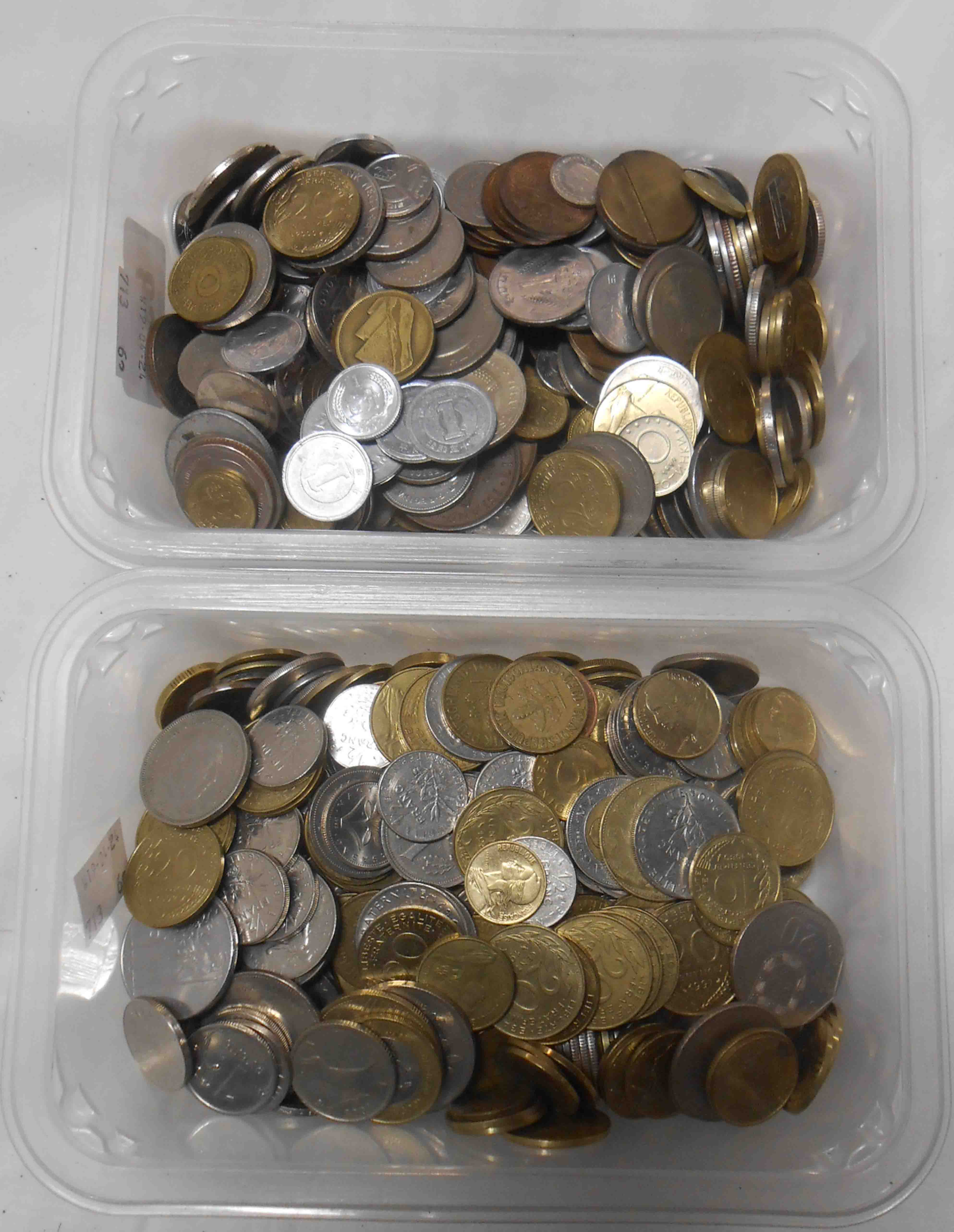 Two containers containing a quantity of world coinage