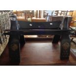 An old ebonised wood framed camel saddle stool with applied brass stud decoration