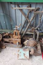 A large old metal lathe with heavy cast iron base