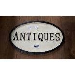 A modern painted cast iron 'Antiques' sign