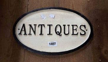 A modern painted cast iron 'Antiques' sign