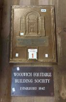 An embossed brass Woolwich Equitable Building Society wall calendar, depicting a building entrance -