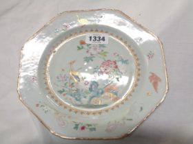 An antique Chinese porcelain plate of octagonal form with famille rose decoration, depicting