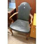 An old part show frame panel back elbow chair with studded dark green leather upholstery, set on