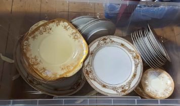 A crate containing a quantity of porcelain and bone china tableware with gilt decoration