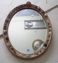 A gilt framed bevelled oval wall mirror with applied shell decoration