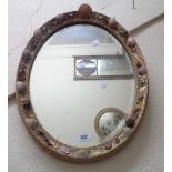 A gilt framed bevelled oval wall mirror with applied shell decoration