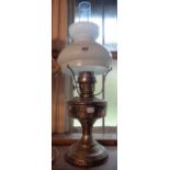 A vintage metal oil lamp with opaque glass shade